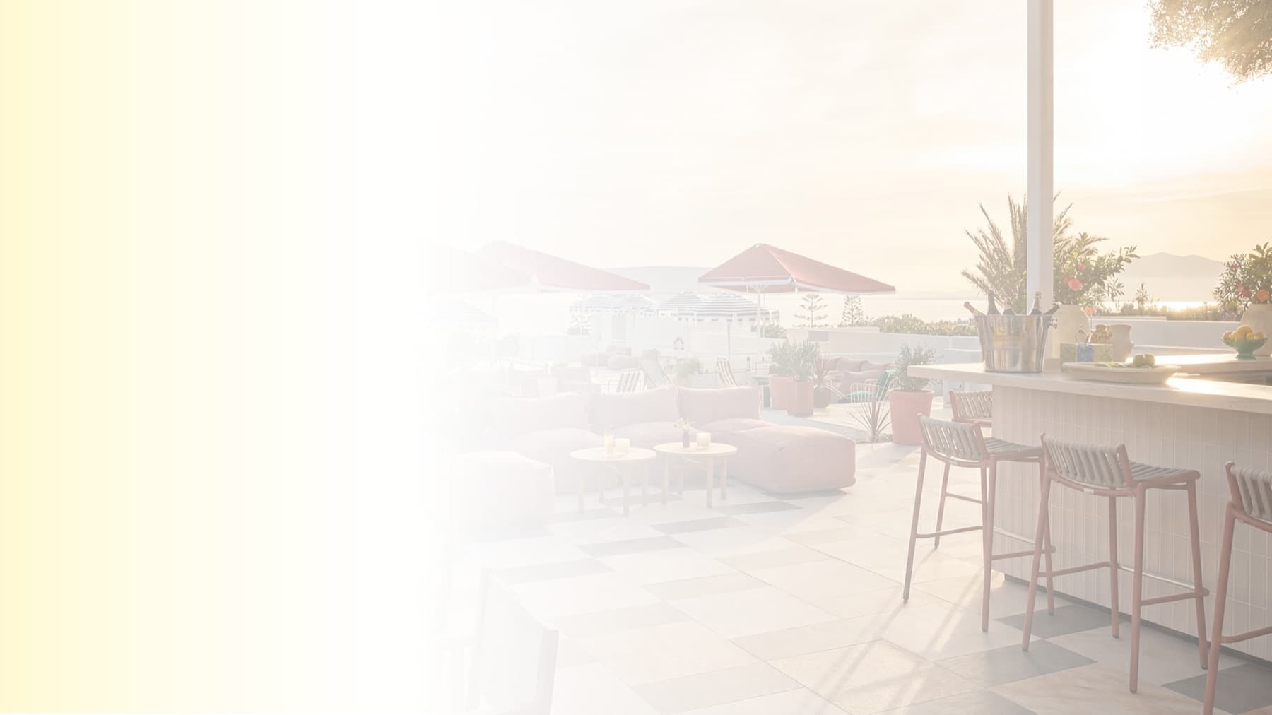 Terraza hospitality luminosa con vistas al mar y mobiliario lounge.
